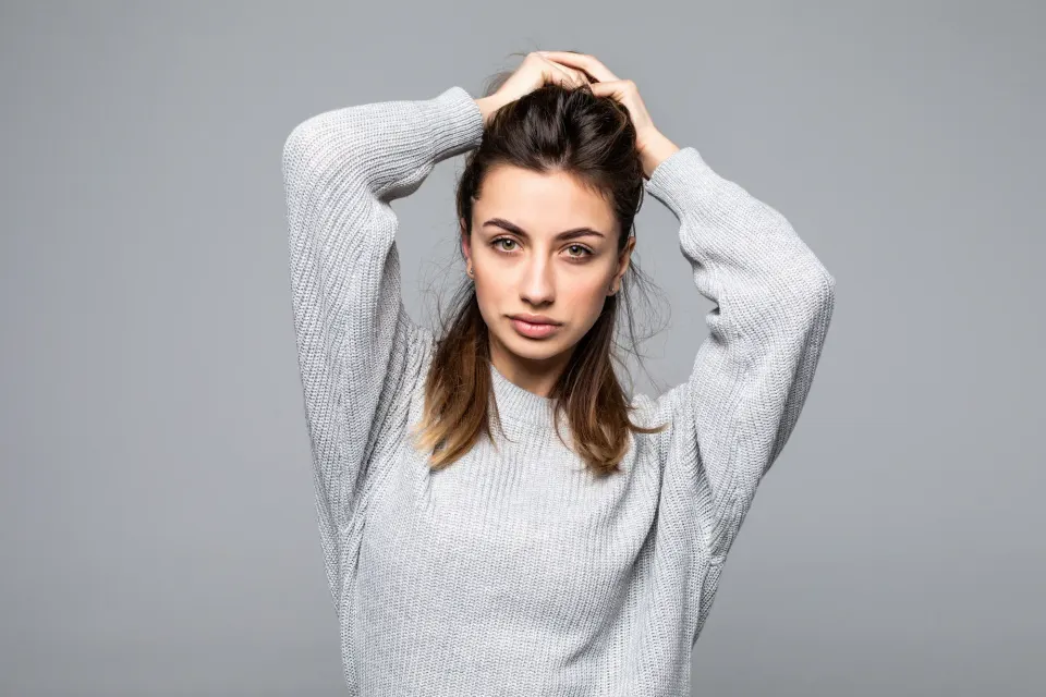 Patient examining widening hair part in soft natural light